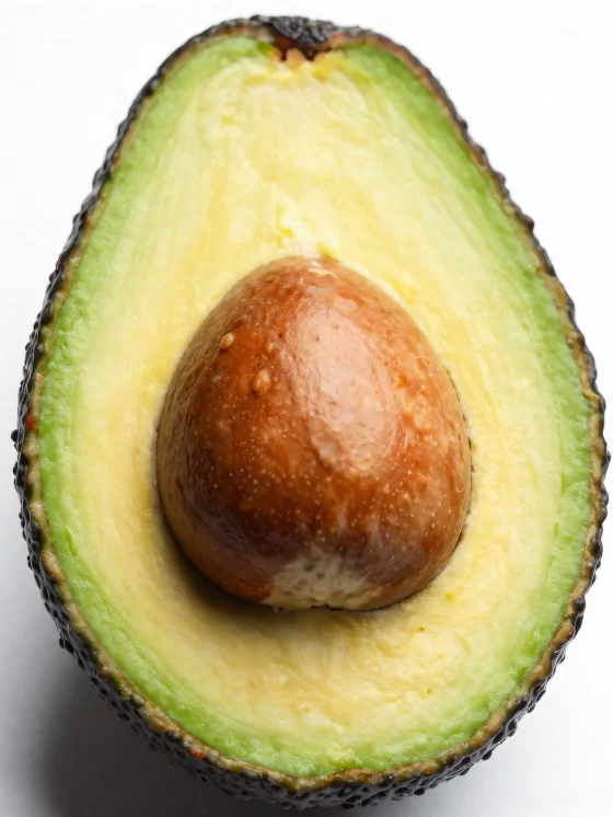 Aufgeschnittene frische Avocado mit cremigem grünem Inneren auf Holzoberfläche