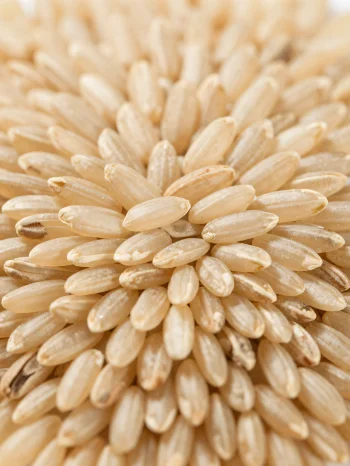 Rohe Naturreiskörner in rustikaler Schale auf der Küchentheke