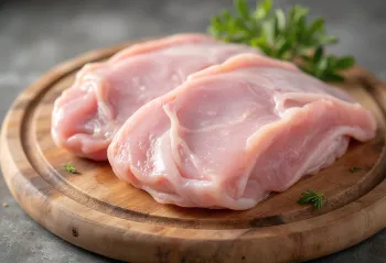 Frische Putenfleischstücke mit Gewürzen und Knoblauch auf einem Holzschneidebrett