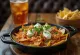 Chilaquiles mit Habanero-Salsa, serviert mit Crème fraîche und Koriander