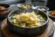 Zucchini-Sujebi Suppe serviert mit frischen Nudeln und Gemüse