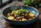 Caldillo mit Rindfleisch, serviert als reiche, würzige Suppe, garniert mit frischem Koriander