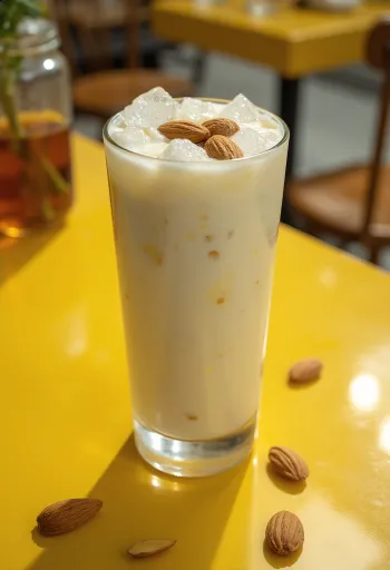 Mandel-Lassi im Glas, mit Eiswürfeln und Mandeln dekoriert