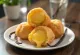 Loukoumades mit Vanillecreme, goldbraun gebacken, innen gelber Pudding, mit Puderzucker bestreut