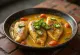 Fischcurry Doi Ilish mit Tomaten und cremiger Joghurtsauce in einer Pfanne