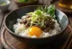 Nattō auf Reis, japanisches Gericht, serviert mit frischem Ei und Frühlingszwiebeln