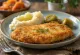Paniertes Schweinekotelett mit Kartoffelpüree und Essiggurken serviert