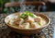 Bicol Express aus Schweinefleisch, serviert mit Kokosmilchsauce und Chilischoten