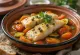 Klassische Tajine mit Fisch, reichhaltig mit Gemüse serviert, frische Gewürze